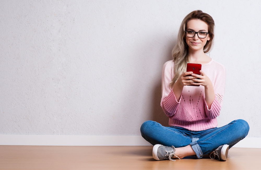 Content is expensive myth: Young woman reading on her mobile phone