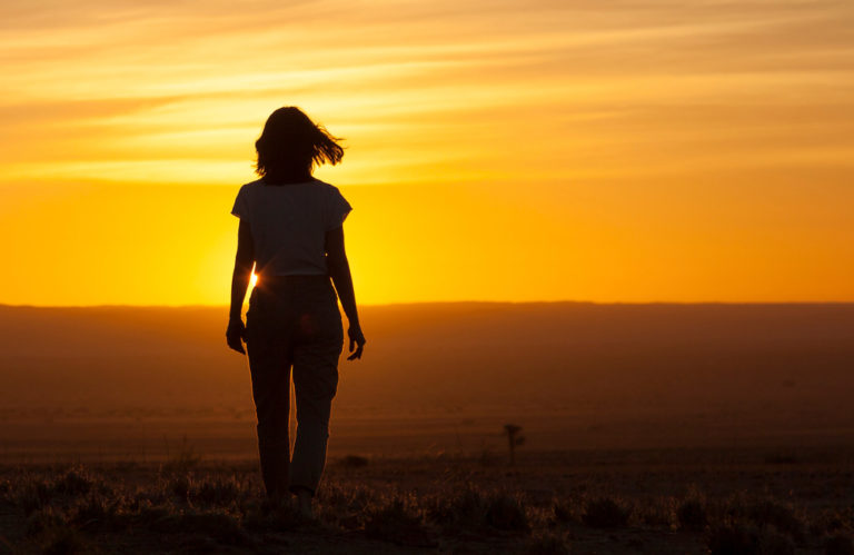 Woman walking into sunset to illustrate lessons learned in 2023