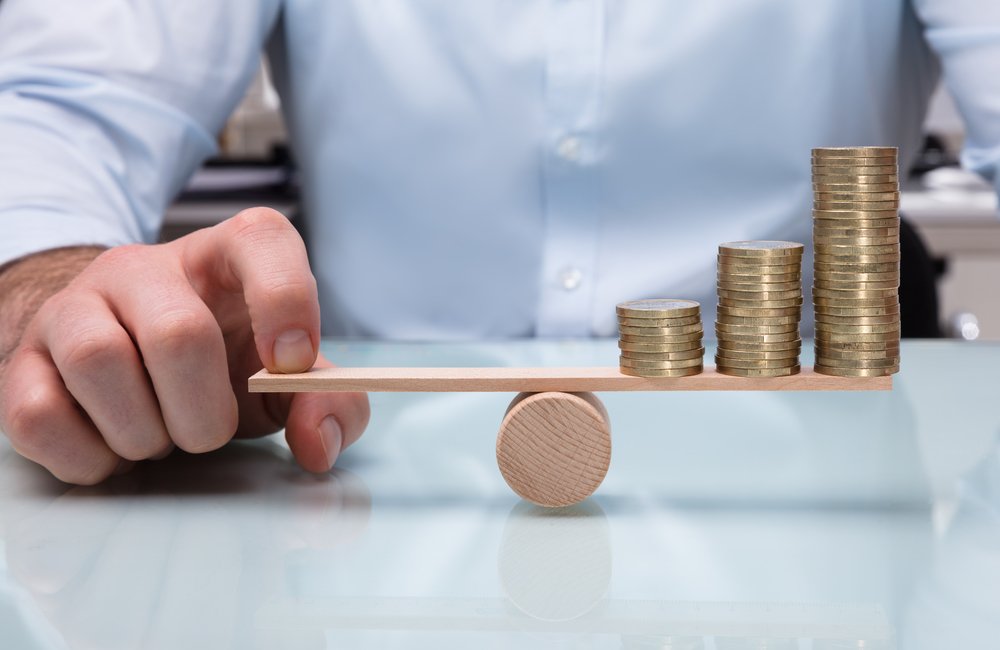 Does discounting work in a recession? Business owner balances coins on a seesaw