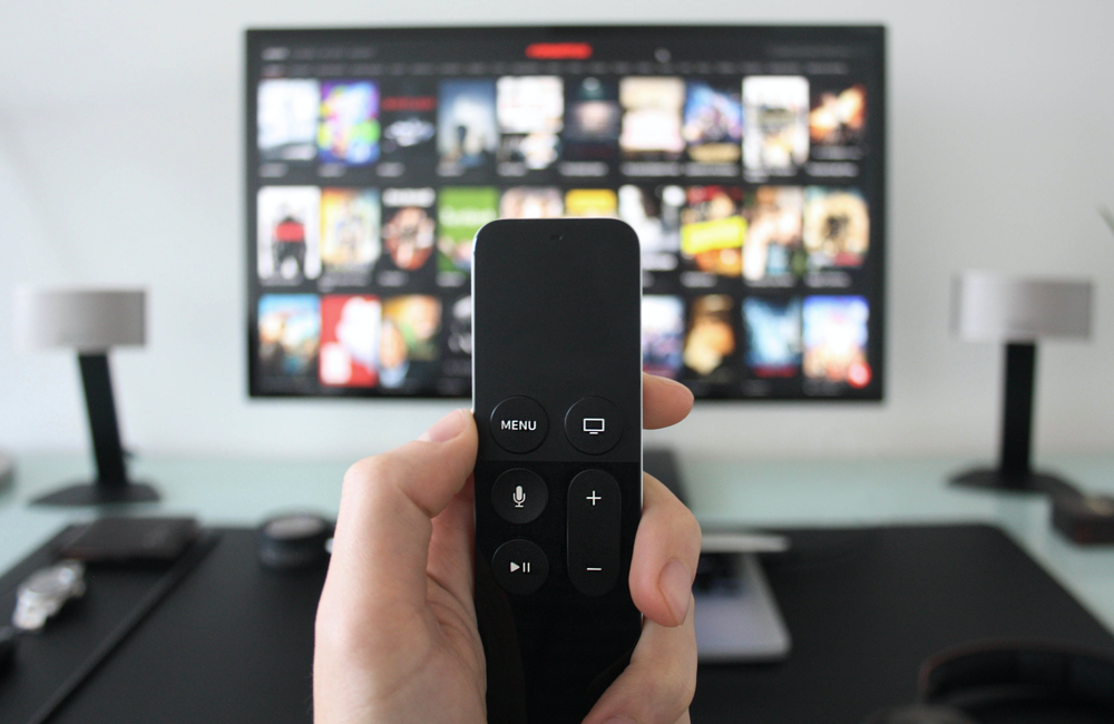 Netflix's struggles teach you about your digital strategy: Hand holding television remote control