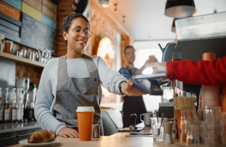 Customer paying for a coffee in a cafe with their mobile phone to illustrate the concept that digital transformation is all about customers