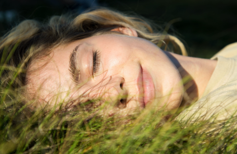 Young woman smiling while lying in the grass