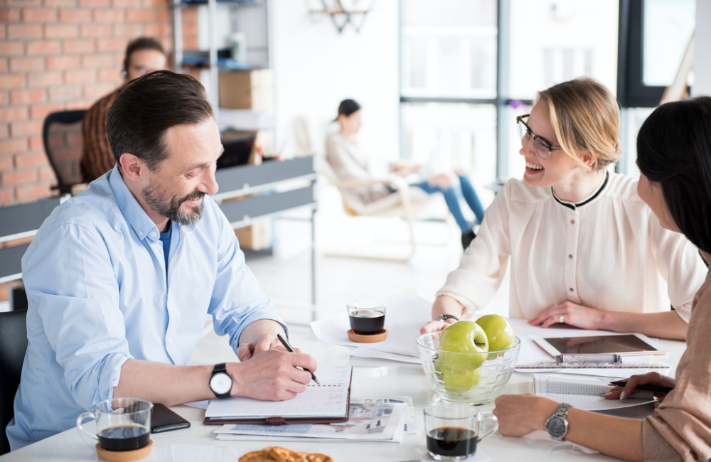 Team collaborates around table as they build their business case for digital.