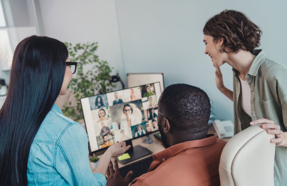 Picture of hybrid team, some in the office, some on video conference, to illustrate how employees and customers live in a difference world now