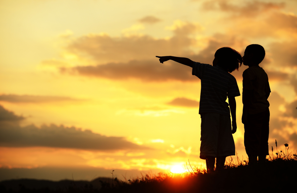 Photo of children pointing to the horizon in silhouette to illustrate the concept of recapping 2022