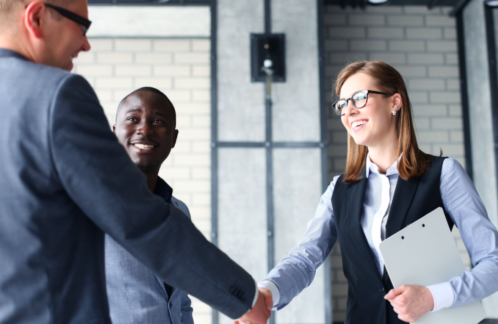 Photo of customers shaking hands with business team to illustrate the idea of making our customers lives better