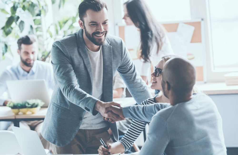 Group of people shaking hands on a deal to illustrate the idea of how to succeed this year, next year, and every year beyond that.
