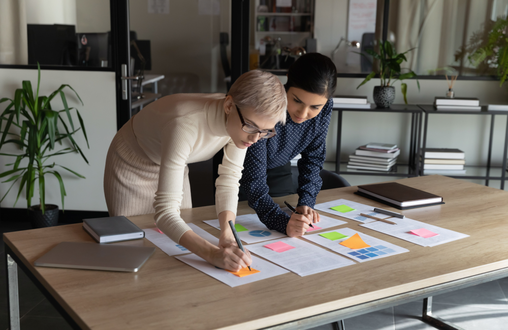 Photo of two women from a business working together to set goals and plan their strategy